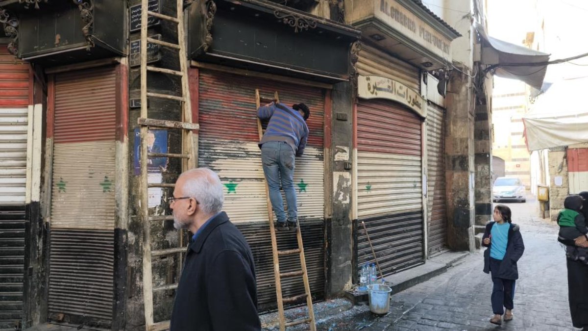 Şam’da esnaflar kepenklerindeki eski Suriye bayraklarını kazımaya başladı
